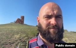 Gonzalez posiert vor dem Denkmal bekannt als "Tatik-Papik" (Großmutter und Großvater") in Berg-Karabach.