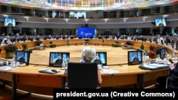 Президент Украины Владимир Зеленский (на экране) во время видеообращения к участникам заседания Европейского совета, которые позже проголосовали за начало переговоров о вступлении Украины в ЕС. Брюссель. Бельгия, 14 декабря 2023 года