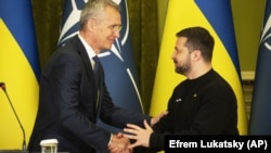 Secretarul general al NATO, Jens Stoltenberg (stânga) îl așteaptă pe președintele Volodimir Zelenski, miercuri, la inaugurarea Consiliului NATO-Ucraina. Kievul nu va primi acum invitația de a adera, e în război, dar va primi ajutor și promisiunea unui viitor în Alianță.