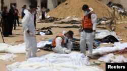 Медицински тим ги проверува телата на Палестинците убиени во израелска воена офанзива во близина на болницата „Насер“ во Кан Јунис, јужниот дел на Појасот Газа, на 21 април 2024 година.