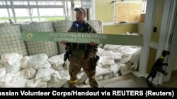 Боєць «Російського добровольчого корпусу» фотографується зі знаком на російському прикордонному пункті, 22 травня 2023 року