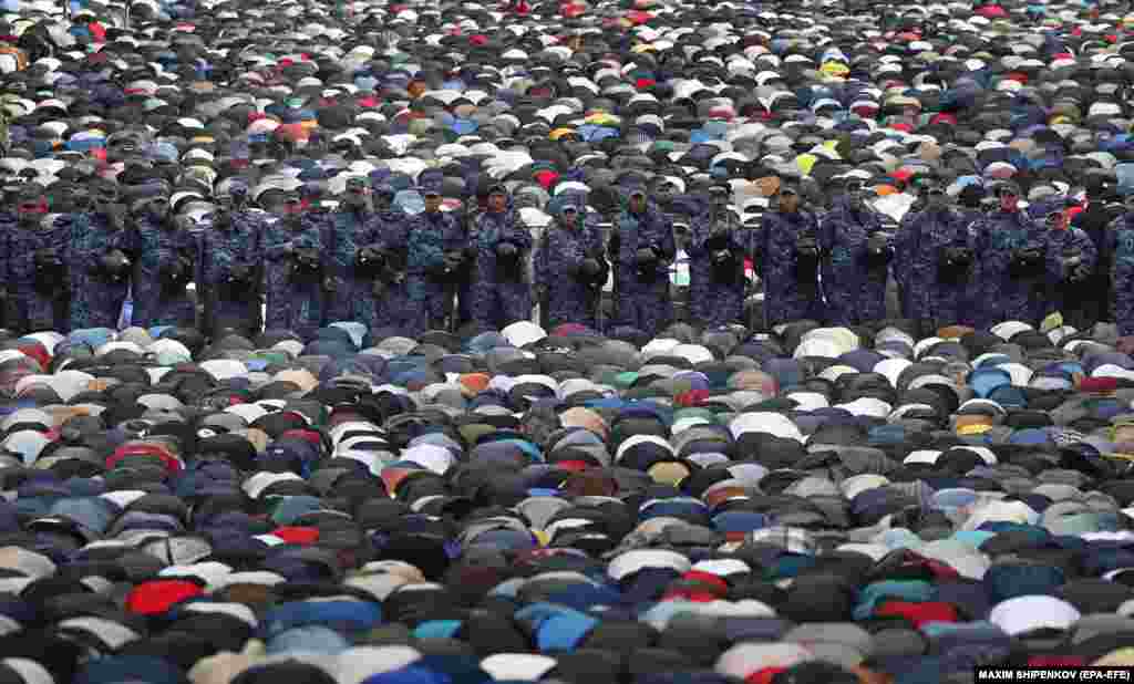 Police officers stand guard while Muslims attend morning prayers to celebrate Eid al-Adha near the Moscow Cathedral Mosque in Moscow on June 28. Eid al-Adha is the holiest of the two Muslims holidays celebrated each year and marks the yearly Muslim pilgrimage to visit Mecca in Saudi Arabia, the holiest place in Islam.