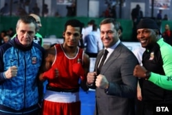  Ибаниес (в червено), до него вдясно е ръководителят на Българската федерация по бокс Красимир Инински, а до него се вижда треньорът на националния тим Жоел Еухенио Солер Арате. 