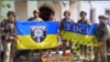 Ukrainian forces hold up flags in celebration of liberating the village of Pyatykhatky in the Zaporizhzhya region on June 19.