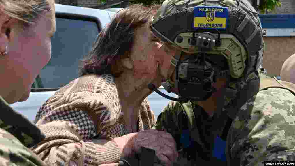 An elderly woman kisses a Ukrainian soldier after she was evacuated from a flooded area in Kherson.