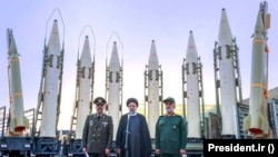 President Ebrahim Raisi (center) stands in front of Iranian missiles with other top officials last August.