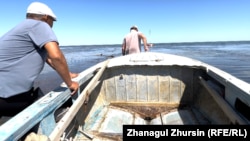 Mukangazi Ibaev (left) and a friend pull a motorboat out to deeper water on the Little Aral Sea on August 22.