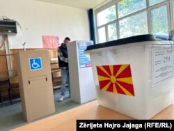 Një burrë duke mbushur fletën e votimit në një vendvotim në Shkup.