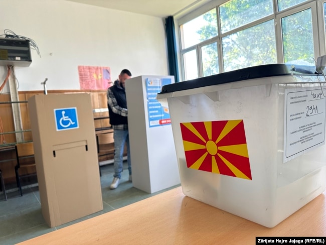 Një burrë duke mbushur fletën e votimit në një vendvotim në Shkup.