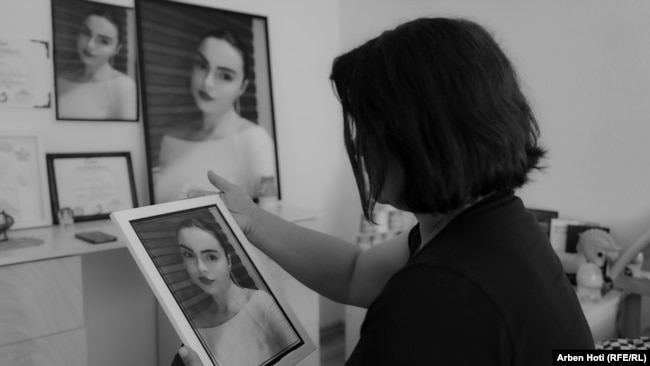 Nëna e Erona Coklit, Milihatja, mban në duar fotografinë e vajzës së saj.