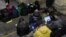 People check their devices for information in a Kyiv subway station during an air raid in March 2023.