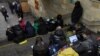 Njerëzit duke i shikuar pajisjet e tyre për të dhëna në një metro në Kiev gjatë një paralajmërimi për sulme ajrore, mars 2023.