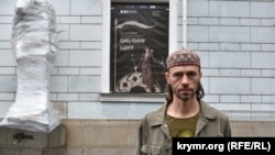 Рустем Скибин возле Киевской картинной галереи перед открытием выставки, о которой сообщает объявление на стене здания