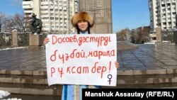 Активист Лия Берген "Досаев, салтты бузба, жүрүшкө уруксат бер!" деген плакатты көтөрүп турат. Алматы, Казакстан. 