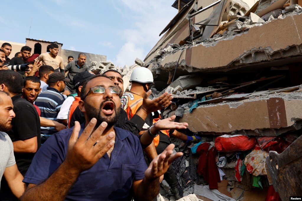 Banorët e Rripit të Gazës kërkojnë të mbijetuar nëpër rrënojat e një shtëpie të shkatërruar nga sulmet izraelite në lagjen Kan Jounis.