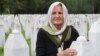 A woman touches a gravestone at the memorial cemetery in Srebrenica, Bosnia-Herzegovina.