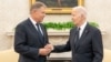 U.S. President Joe Biden (right) welcomes Romanian President Klaus Iohannis to the Oval Office on May 7.