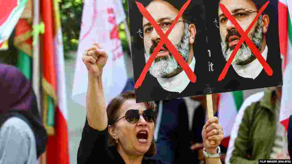Участница антиправительственного протеста держит плакат с изображением Раиси перед посольством Ирана в Берлине. Раиси получил прозвище «Тегеранский мясник» за то, что был одним из судей, надзиравших за казнями тысяч политических заключённых в конце 1980-х