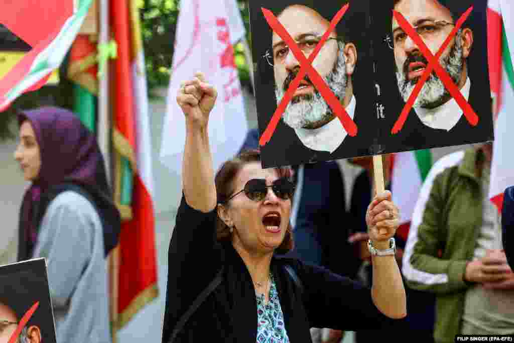 A protester holds a placard against Raisi during a protest of the National Council of Resistance of Iran against the Iranian regime in front of the Iranian Embassy in Berlin.