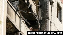 Чоловік дивиться з вікна зруйнованої квартири в місті Вугледар, Донецька область, 16 липня 2023 року