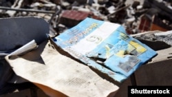 Підручник з географії на тлі руїн школи після удару російської армії. Харків, 2022 рік