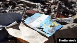 Учебник по географии на фоне развалин школы после удара российской армии. Харьков, 2022