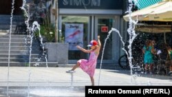  Момиче играе във шадраван в Прищина, Косово, по време на горещата вълна, 18 юли. 