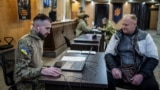 Dobrovoljac koji se nada da će ući u ukrajinsku 3. odvojenu jurišnu brigadu razgovara sa oficirima u regrutnoj kancelariji, 9. januar 2024.