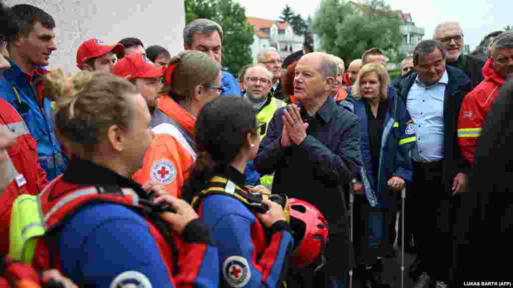 Olaf Scholz német kancellár köszönetet mond a vízimentő szolgálat munkatársainak az árvíz sújtotta területeken tett látogatása során a dél-németországi Reichertshofenben 2024. június 3-án.&nbsp;Scholz elmondta, hogy Németországban az embereknek egyre inkább alkalmazkodniuk kell a természeti katasztrófákhoz, különösen az árvizekhez, amelyeket az ember okozta klímaváltozás következményeinek tartanak