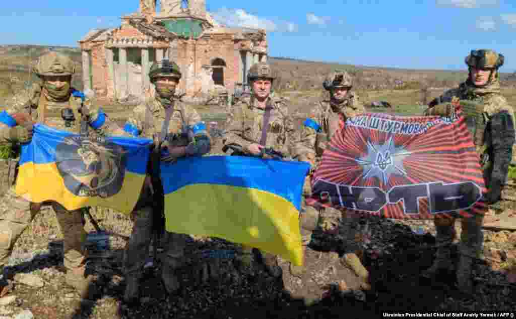 A handout photograph released by Kyiv shows Ukrainian soldiers posing with Ukrainian national flags in front of a destroyed building in the village of Klishchiyivka on September 17. President Volodymyr Zelenskiy announced that Ukrainian forces had liberated Klishchiyivka, a village on the southern flank of Bakhmut. The announcement came two days after Ukraine&#39;s military said it had gained control of a small nearby village, Andriyivka, about 10 kilometers southwest of Bakhmut. &nbsp;