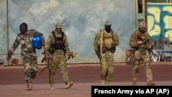  This undated photograph handed out by the French military shows three Russian mercenaries (right) in northern Mali. Russia's Wagner Group has deployed its personnel to Syria, Central African Republic, Libya, and Mali.