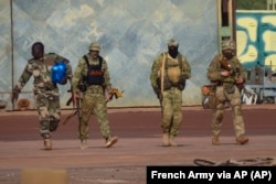 An undated photograph handed out by the French military shows three Wagner mercenaries (right) in northern Mali.