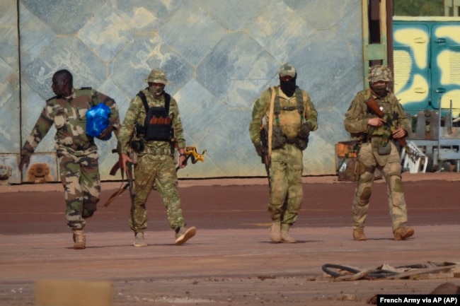 An undated photograph handed out by the French military shows three Wagner mercenaries (right) in northern Mali.