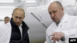 Yevgeny Prigozhin and then-Russian Prime Minister Vladimir Putin (left) in St. Petersburg in 2010. 