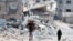 Palestinci prolaze pored kuća koje su uništene u izraelskom napadu, Kan Junis, jug Pojasa Gaze, 22. maja 2024.