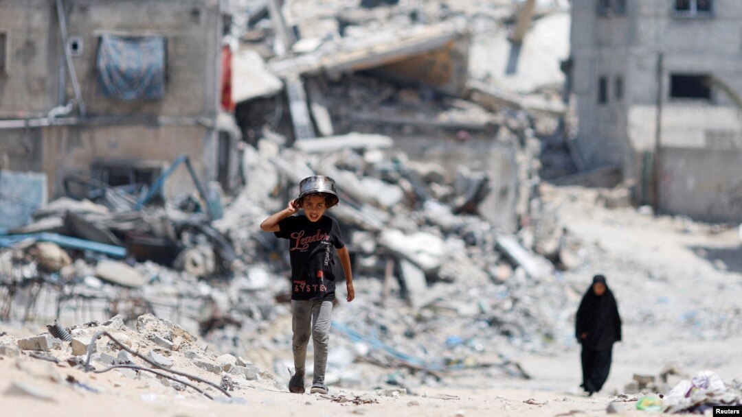 Un copil fotografiat printre dărâmăturile din Gaza. 36.000 de persoane din Fâșie au murit în urma atacurilor israeliene din octombrie 2023. 