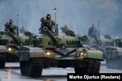 Сербские военные отдают воинское приветствие с башен своих танков во время военного парада в честь 70-летия освобождения Белграда Красной Армией, 16 октября 2014 года