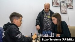 Jona dhe Rroni duke luajtur shah, teksa trajneri Gani Hamiti i shikon.