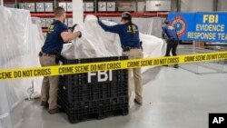  Специални сътрудници на ФБР обработват материал, извлечен от балона, свален край крайбрежията на Южна Каролина дни по-рано. Лабораторията на ФБР в Куантико, Вирджиния, 9 февруари 2023 година 