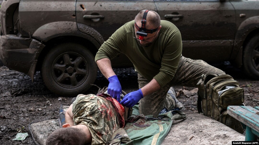Un paramedic militar tratează un soldat ucrainean rănit în luptele de stradă cu forțele rusești, în orașul de pe linia frontului Bahmut, regiunea Donețk, 23 aprilie 2023.