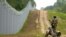 A Latvian Border Guard officer patrols along the fence at the Latvian-Belarus border near Robeznieki in August.