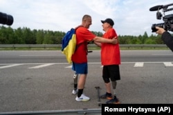 Amputáltak – A 2014-es harcok két veteránja, Szerhij Hrapko (jobbra) és Olekszandr Svecov 120 kilométeres gyaloglásuk végén, amivel orvosi felszerelésekre gyűjtöttek pénzt a háborúban megsebesült bajtársaiknak. Jurij, 2023. május 19.