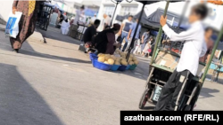 Aşgabadyň bazarynda galtakly ýük daşap gazanç edýän oglan. Türkmenistan (arhiw suraty).