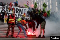 Francuski željezničari SNCF-a u štrajku drže transparente sindikata Sud Rail i CGT na kojima piše "Ne mirovinskoj reformi" i crvene baklje u Puteauxu blizu Pariza, 20. april 2023.