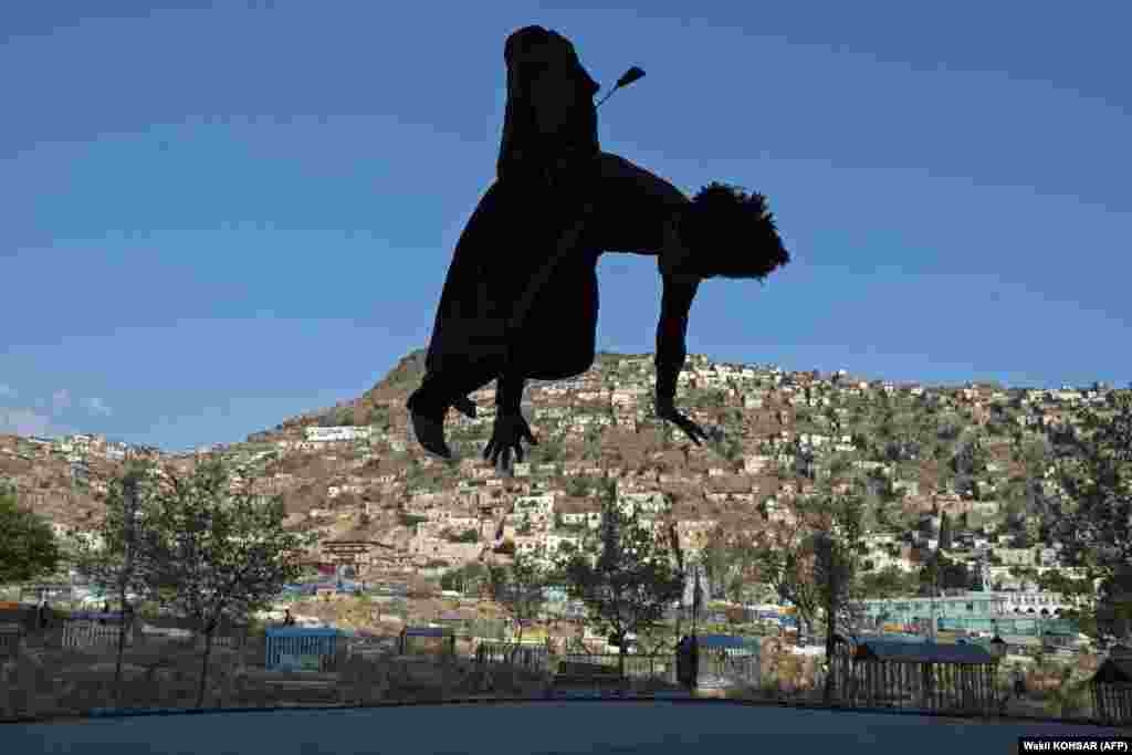 An Afghan youth jumps on a trampoline at the Kart-e Sakhi cemetery in Kabul.