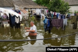 Місцевий мешканець гуляє затопленим подвір’ям свого будинку в Афанасіївці, Миколаївська область, 10 червня 2023 року, після пошкодження дамби Каховської гідроелектростанції