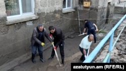 Armenia- People shovel mud from a flooded courtyard in Alaverdi, May 28, 2024.
