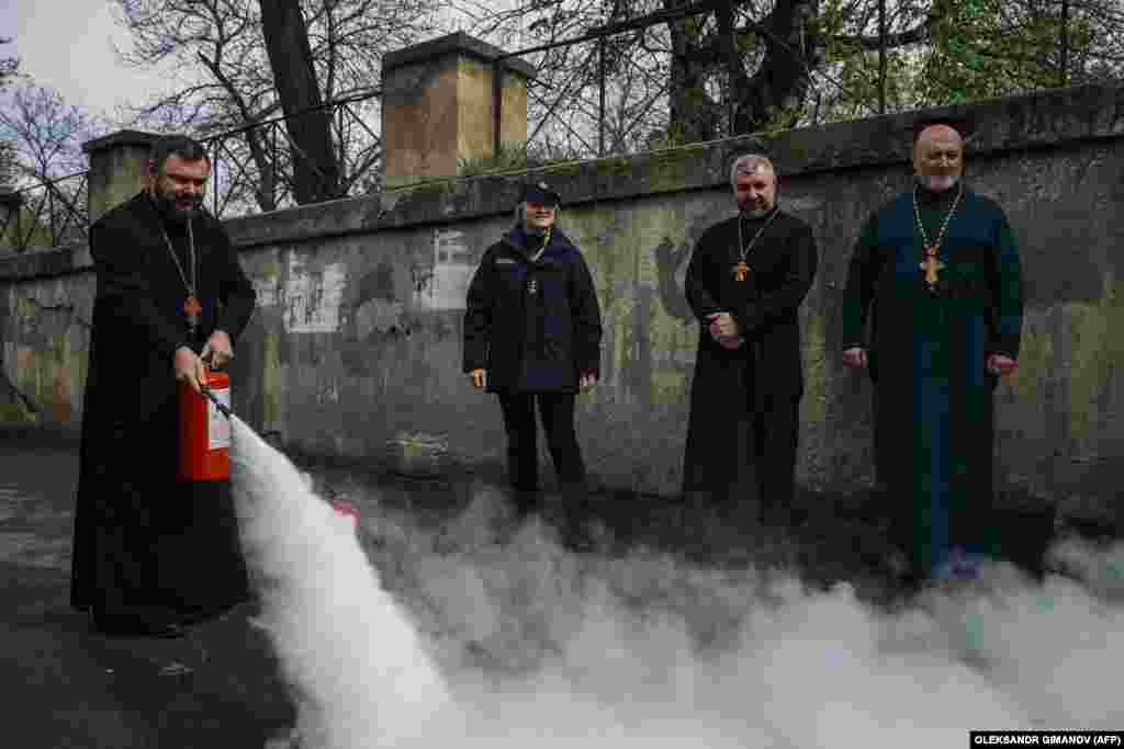 Ukrainian priests learn how to use a fire extinguisher on the eve of Orthodox Christian Easter in Odesa on April 12.
