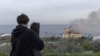 Пара дивиться на палаючу будівлю, пошкоджену внаслідок ракетного удару, Одеса, 29 квітня 2024 року