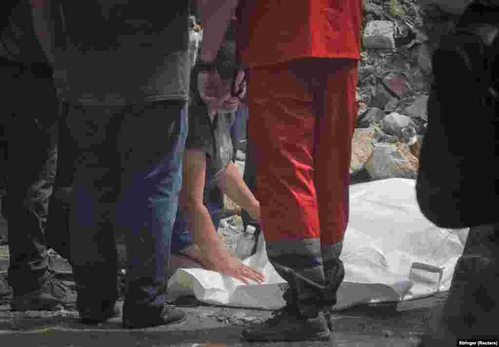 Жінка біля тіла свого сина, який загинув внаслідок ракетного удару